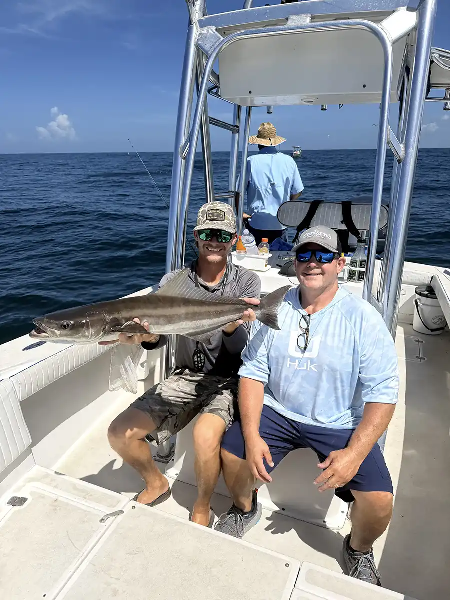Angler holding a cobia aboard a fishing boat off Sarasota, Florida.