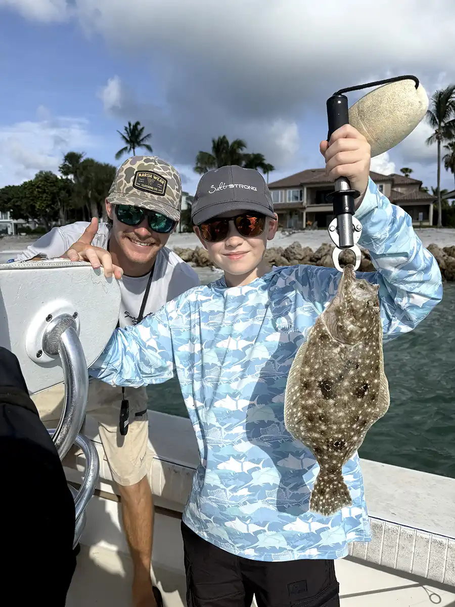 Young angler holding a flounder caught while fishing near Sarasota, Florida.