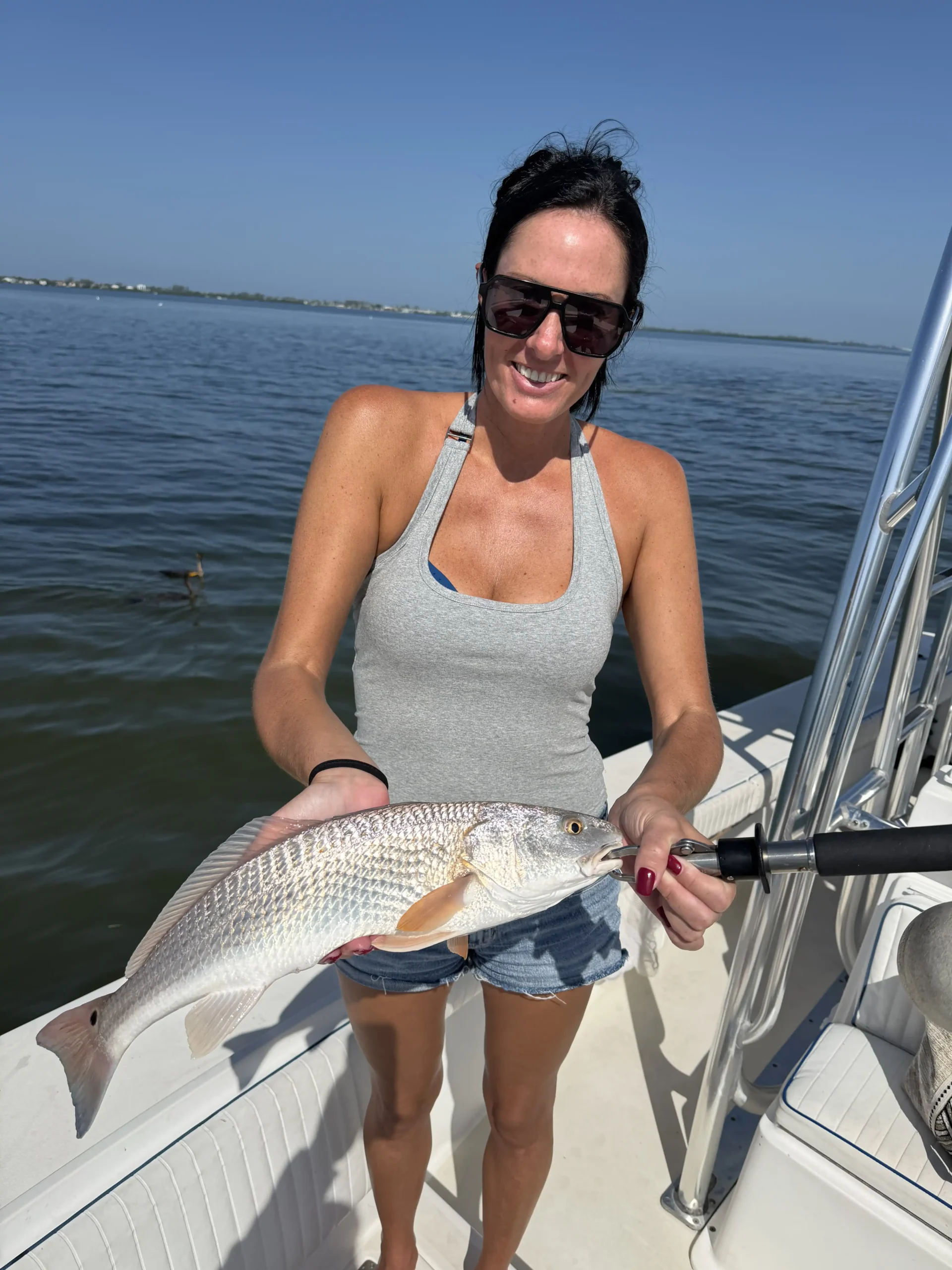 Woman holding a redfish caught while fishing in Sarasota, Florida