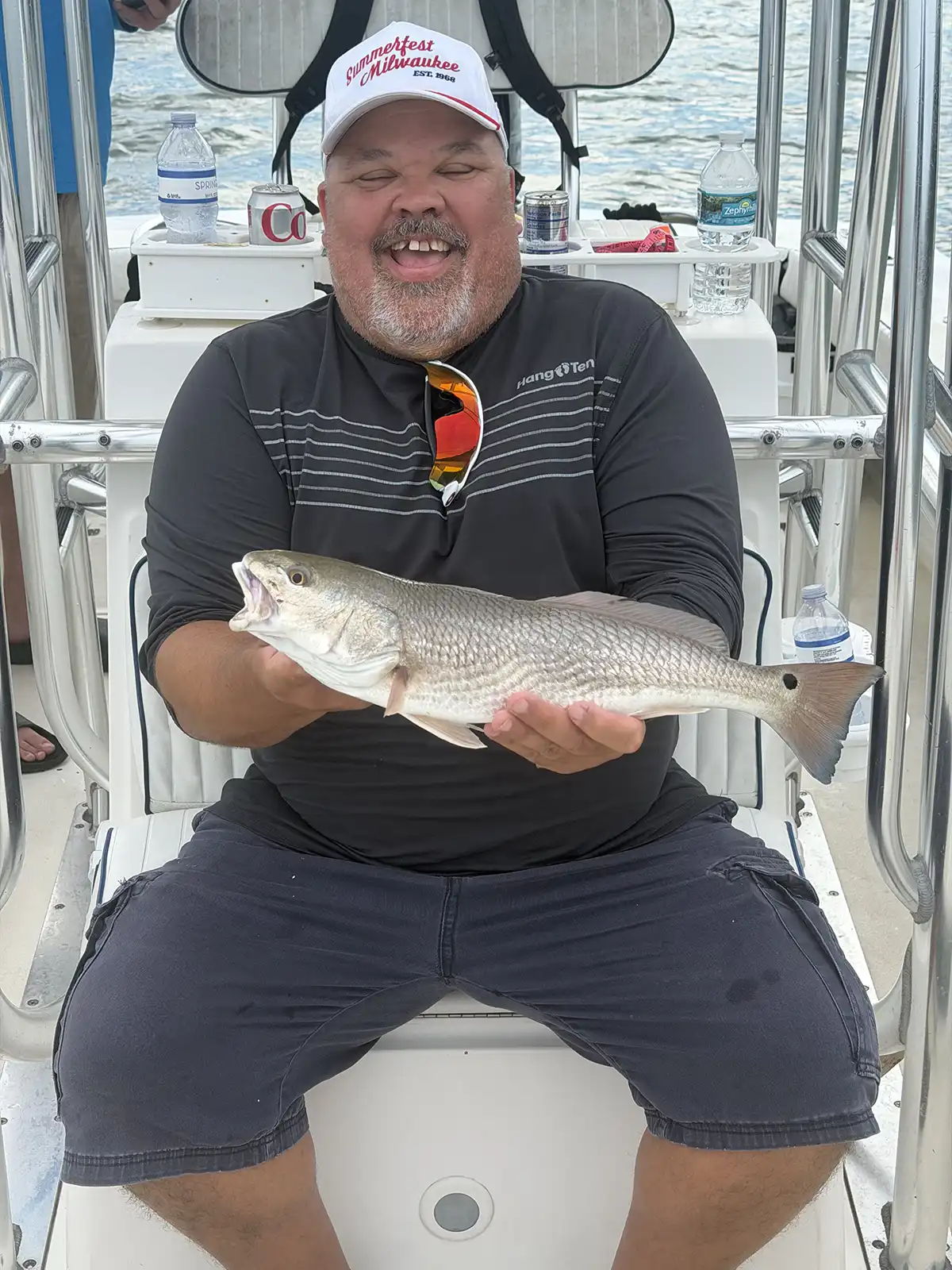 Happy customer holding a redfish caught during a Sarasota fishing charter on Sarasota Bay.