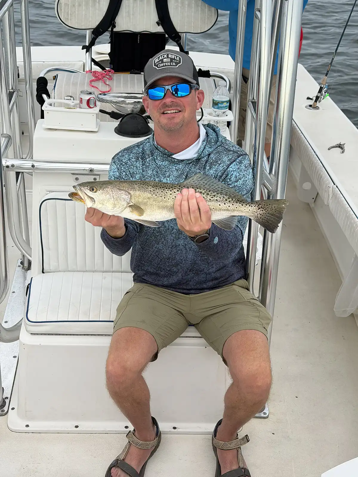 Happy customer holding a redfish caught during a Sarasota fishing charter on Sarasota Bay.