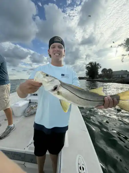 Angler holding a snook caught during an inshore fishing trip in Sarasota, Florida