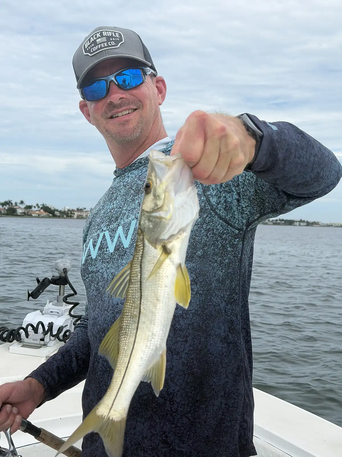 Happy customer holding a snook during a Sarasota fishing charter on Sarasota Bay.