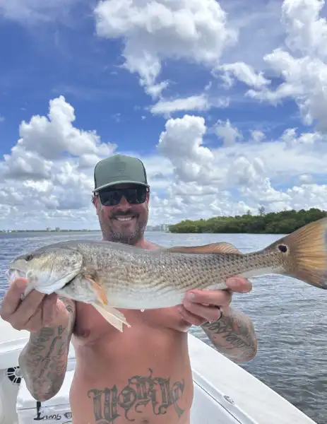 Angler holding a redfish caught while fishing in Sarasota, Florida